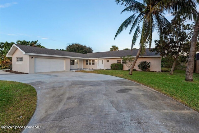 single story home featuring a front lawn and a garage