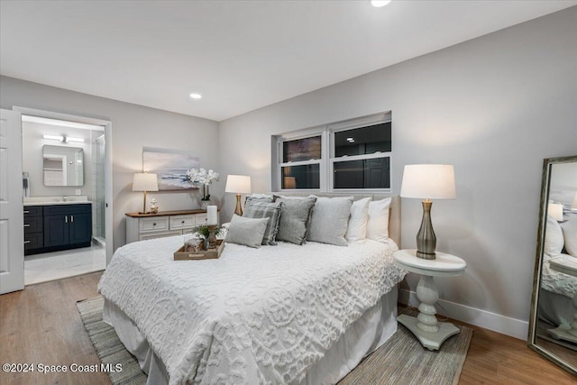 bedroom featuring hardwood / wood-style floors, sink, and connected bathroom