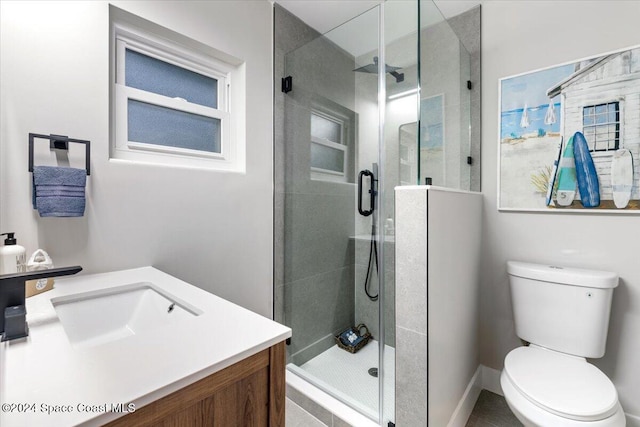 bathroom featuring vanity, a shower with shower door, and toilet