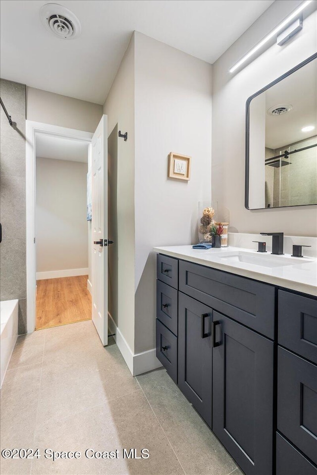 bathroom featuring vanity, hardwood / wood-style flooring, and a shower