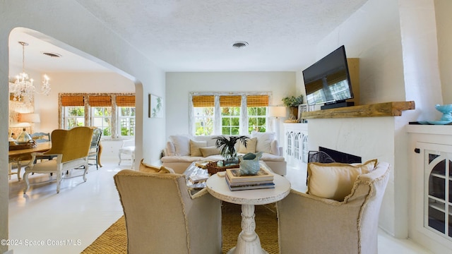 carpeted living room with an inviting chandelier and a textured ceiling