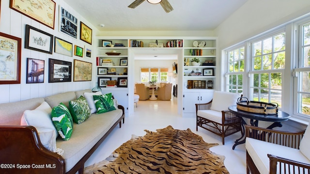 sitting room featuring built in features, a wealth of natural light, and ceiling fan