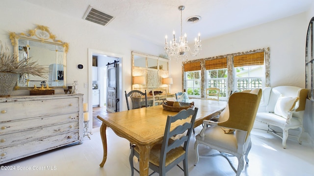 dining area featuring a barn door and a chandelier