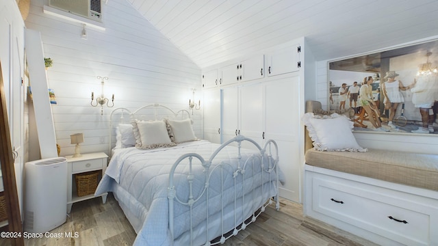 bedroom with wood walls, wooden ceiling, wood-type flooring, lofted ceiling, and a closet