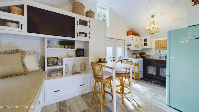 kitchen featuring white cabinetry, pendant lighting, light hardwood / wood-style floors, and white appliances