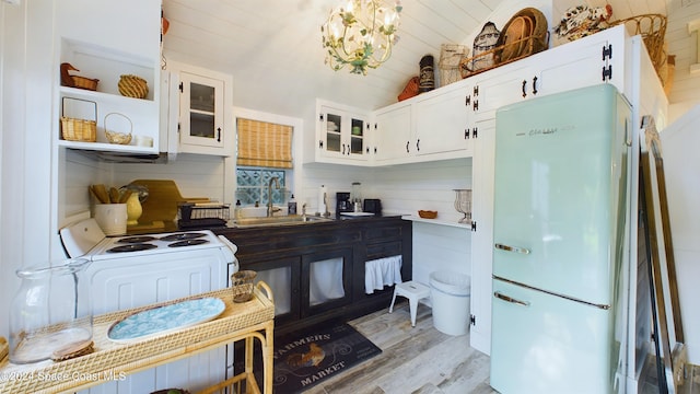 kitchen featuring white cabinetry, sink, vaulted ceiling, white appliances, and light hardwood / wood-style flooring