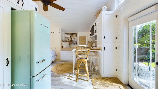 kitchen featuring built in desk, ceiling fan, white cabinetry, and white refrigerator