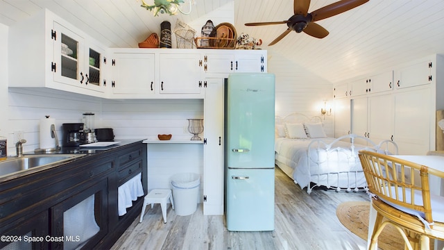 kitchen featuring white cabinets, light hardwood / wood-style flooring, and lofted ceiling