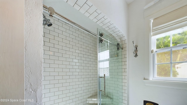 bathroom with an enclosed shower and a healthy amount of sunlight