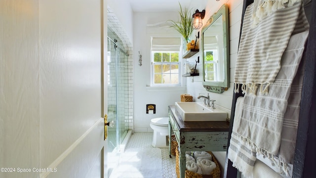 bathroom featuring vanity, a shower with shower door, tile patterned floors, and toilet