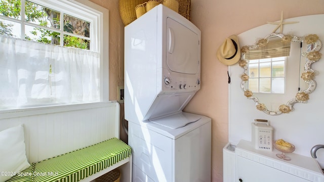 clothes washing area featuring stacked washing maching and dryer