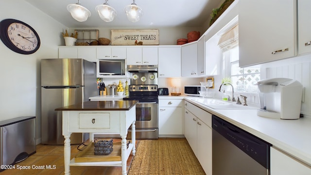 kitchen featuring white cabinetry, appliances with stainless steel finishes, sink, and pendant lighting