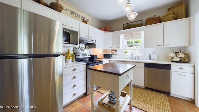 kitchen with white cabinetry, stainless steel appliances, and a center island