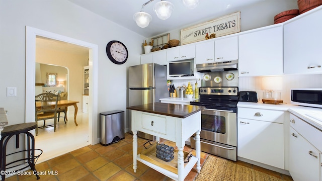 kitchen with decorative light fixtures, tasteful backsplash, stainless steel appliances, and white cabinets