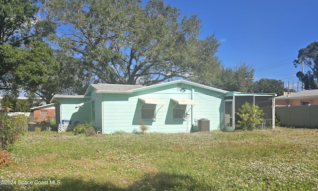 view of front of property with a front yard and central air condition unit