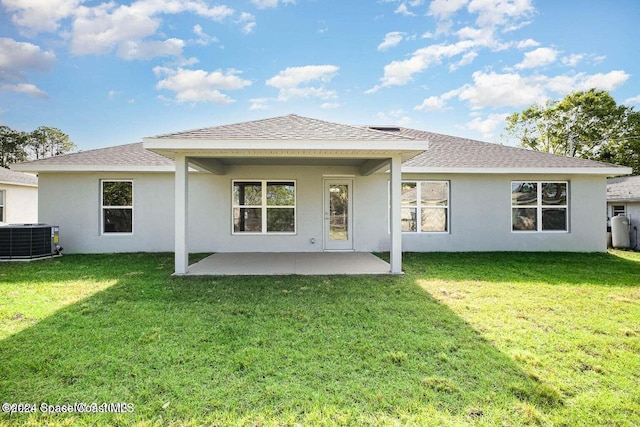 rear view of house featuring a patio, central AC, and a lawn