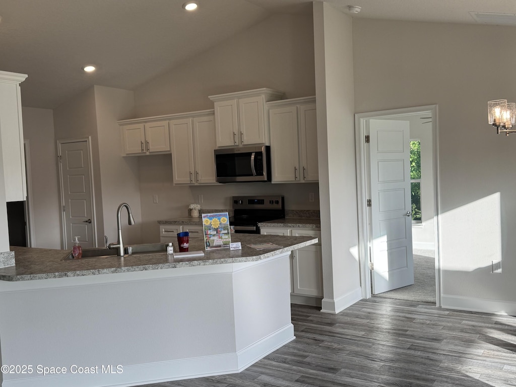 930 San Filippo Dr SE, Palm Bay, FL 32909 - kitchen with appliances with stainless steel finishes, dark wood-type flooring, high vaulted ceiling, white cabinetry, and recessed lighting