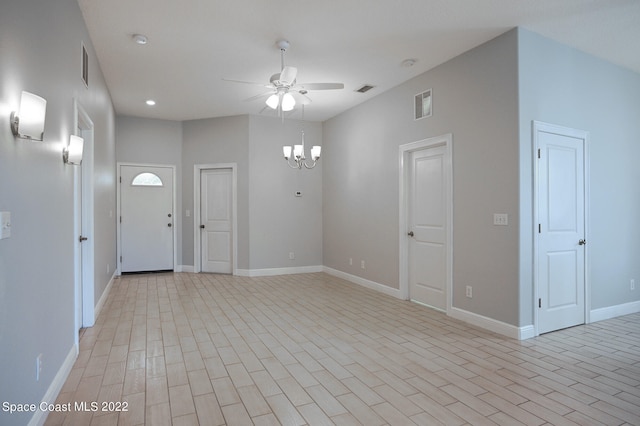 spare room with light wood-type flooring and ceiling fan with notable chandelier