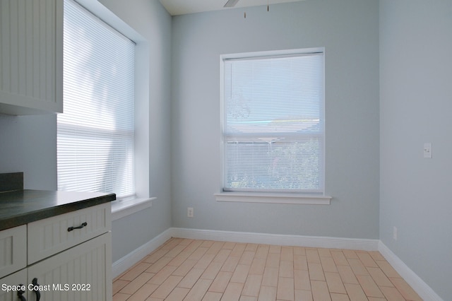 unfurnished dining area with light hardwood / wood-style floors, a healthy amount of sunlight, and ceiling fan