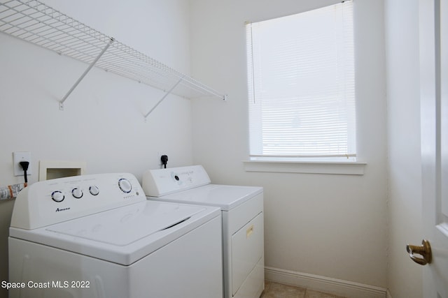 clothes washing area featuring independent washer and dryer and light tile patterned floors