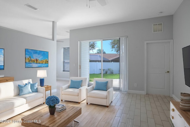 living room with light hardwood / wood-style flooring and ceiling fan