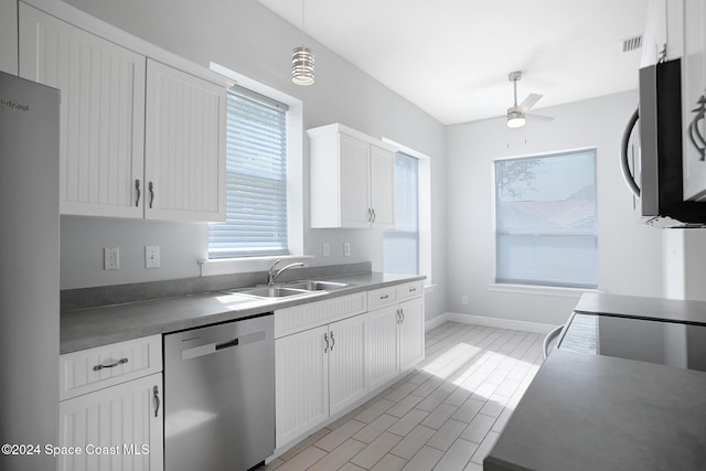 kitchen with white cabinets, stainless steel appliances, sink, and pendant lighting