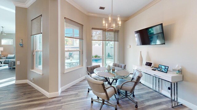 dining space with hardwood / wood-style floors, a healthy amount of sunlight, and ornamental molding