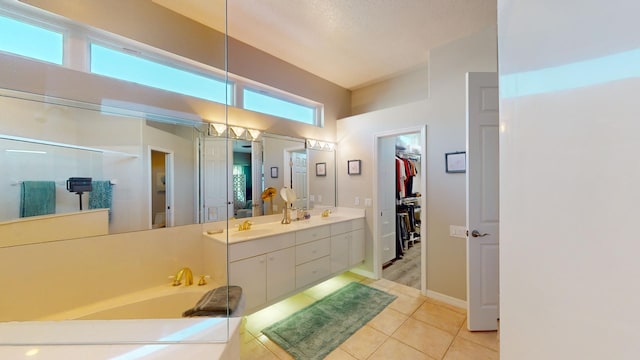 bathroom featuring a bathing tub, vanity, tile patterned floors, and a healthy amount of sunlight