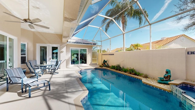 view of swimming pool featuring glass enclosure, ceiling fan, and a patio area