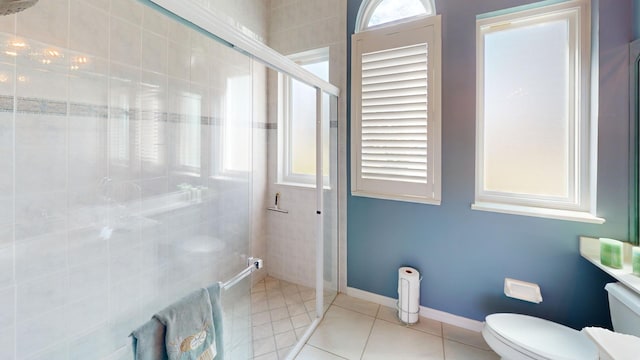 bathroom featuring tile patterned flooring, toilet, and a shower with door