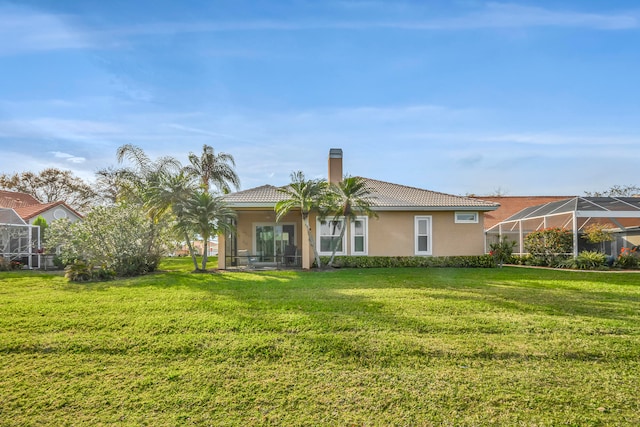 back of house with a lanai and a yard