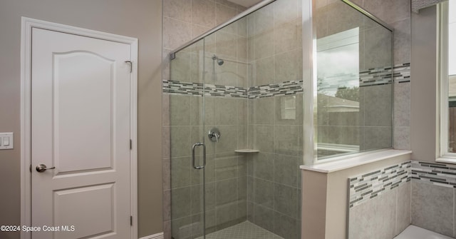 bathroom with a shower with door and tile walls