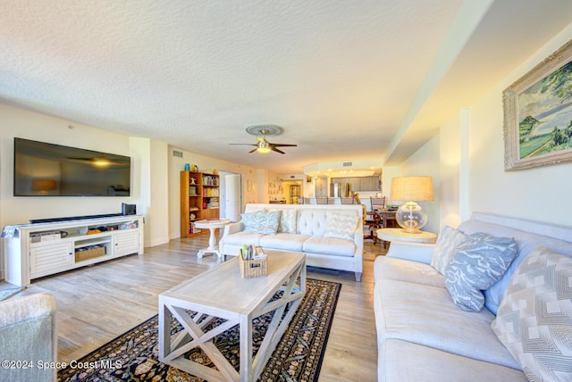 3360 S Atlantic Ave Unit 212, Cocoa Beach, FL 32931 - living room with light wood-type flooring, ceiling fan, and a textured ceiling