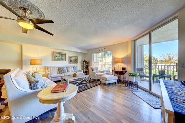 3360 S Atlantic Ave Unit 212, Cocoa Beach, FL 32931 - living room with wood finished floors, ceiling fan, a textured ceiling, and expansive windows