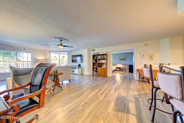3360 S Atlantic Ave Unit 212, Cocoa Beach, FL 32931 - home office with light wood-style floors, a textured ceiling, a ceiling fan, and baseboards