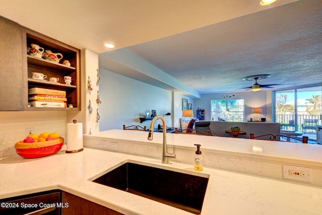 kitchen featuring a textured ceiling, sink, and ceiling fan