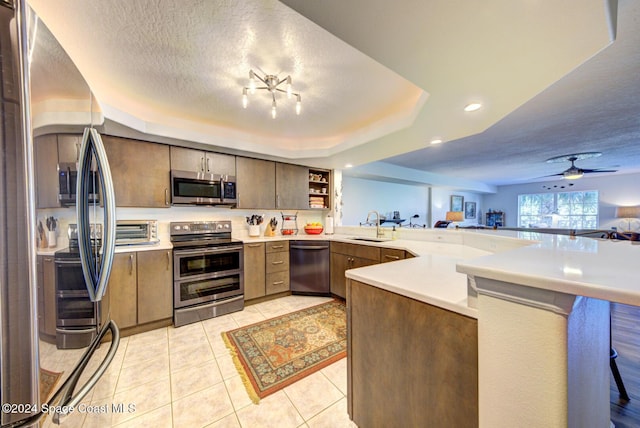 3360 S Atlantic Ave Unit 212, Cocoa Beach, FL 32931 - kitchen with appliances with stainless steel finishes, a peninsula, light countertops, light tile patterned floors, and recessed lighting