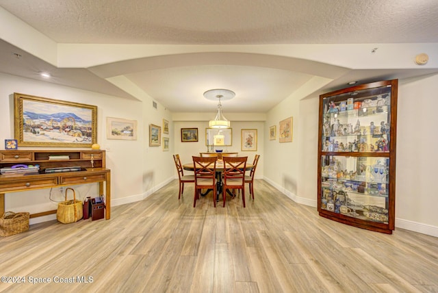 3360 S Atlantic Ave Unit 212, Cocoa Beach, FL 32931 - dining room with light wood-type flooring, baseboards, and a textured ceiling