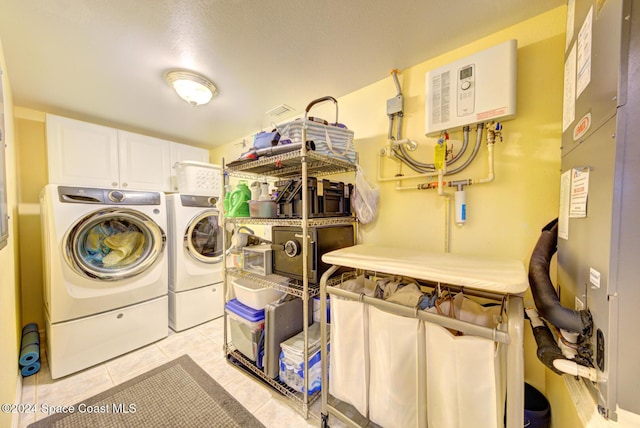 3360 S Atlantic Ave Unit 212, Cocoa Beach, FL 32931 - clothes washing area with light tile patterned flooring, cabinet space, and washing machine and dryer