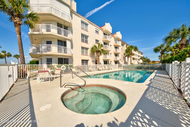 view of swimming pool featuring a patio and a community hot tub