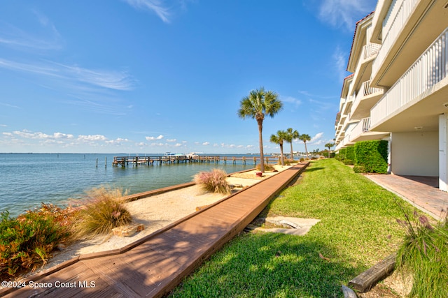 dock area featuring a water view and a lawn