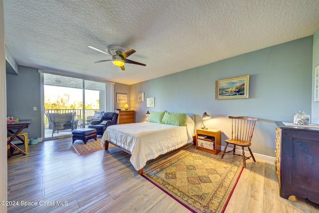 3360 S Atlantic Ave Unit 212, Cocoa Beach, FL 32931 - bedroom with access to outside, wood finished floors, a textured ceiling, baseboards, and ceiling fan