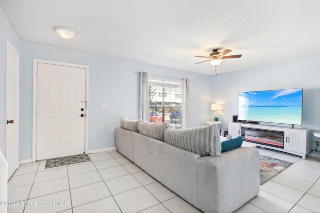 living room with a textured ceiling, light tile patterned floors, and ceiling fan