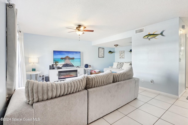 tiled living room with ceiling fan and a textured ceiling