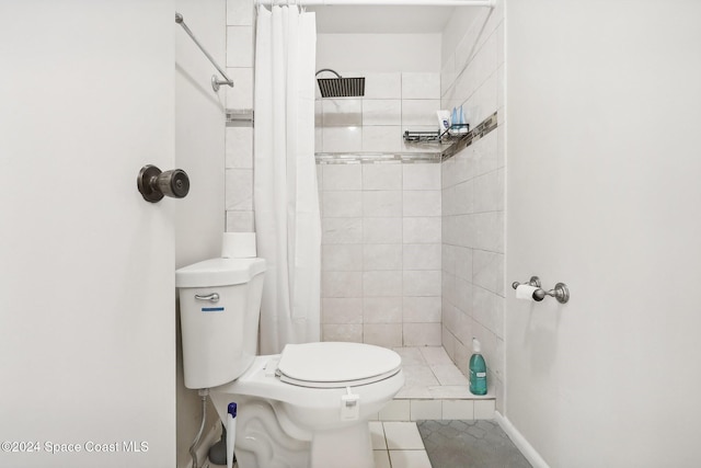 bathroom featuring curtained shower, toilet, and tile patterned flooring