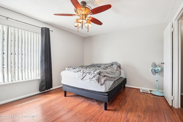 bedroom with multiple windows, a textured ceiling, hardwood / wood-style flooring, and ceiling fan