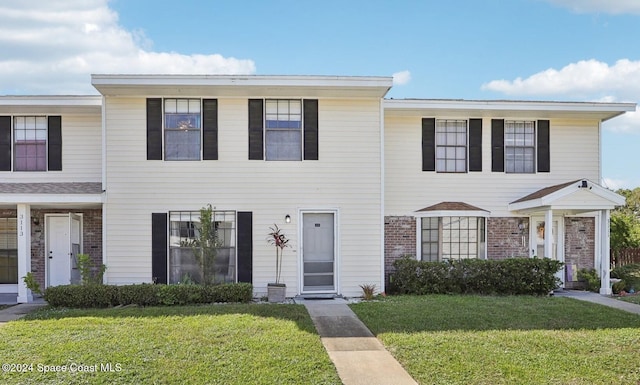 townhome / multi-family property featuring a front yard