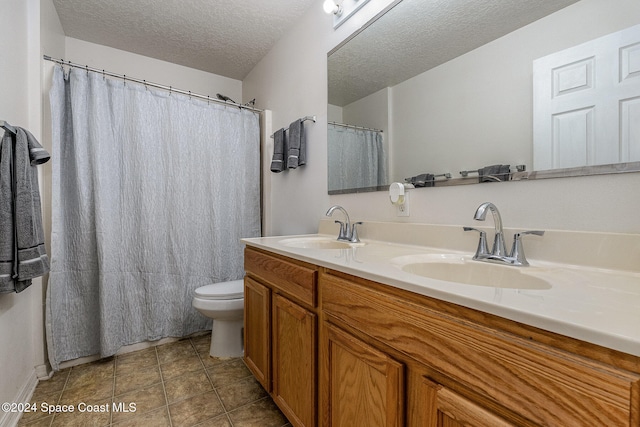 bathroom featuring tile patterned floors, vanity, toilet, and a textured ceiling