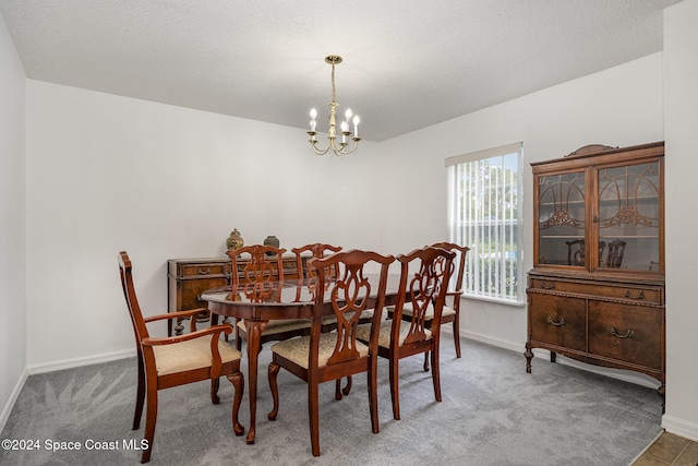 carpeted dining room featuring a notable chandelier and a textured ceiling