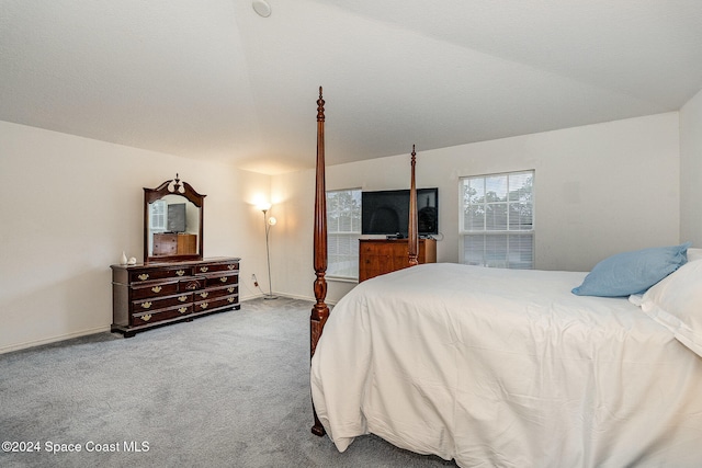 bedroom featuring light colored carpet and vaulted ceiling